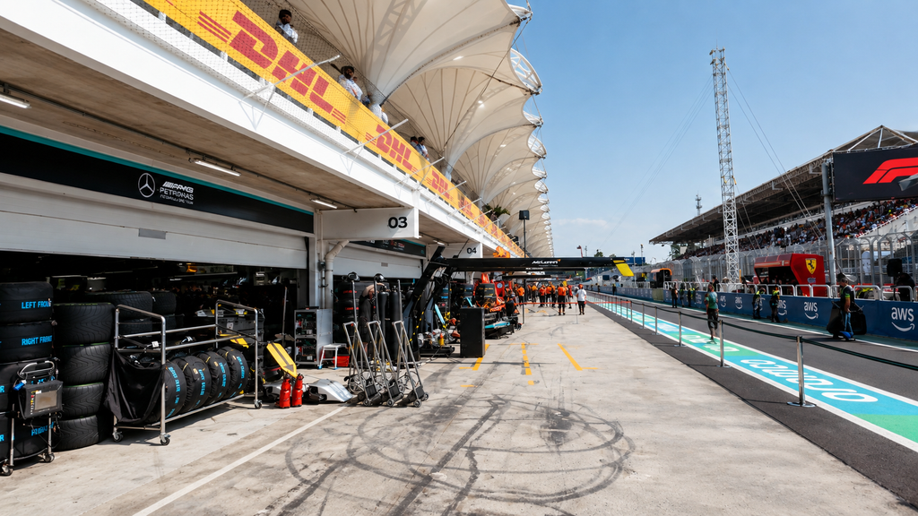 An empty pit lane with a red light glowing at the exit