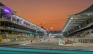 Formula 1 circuit illuminated at sunset with grandstands and track lights