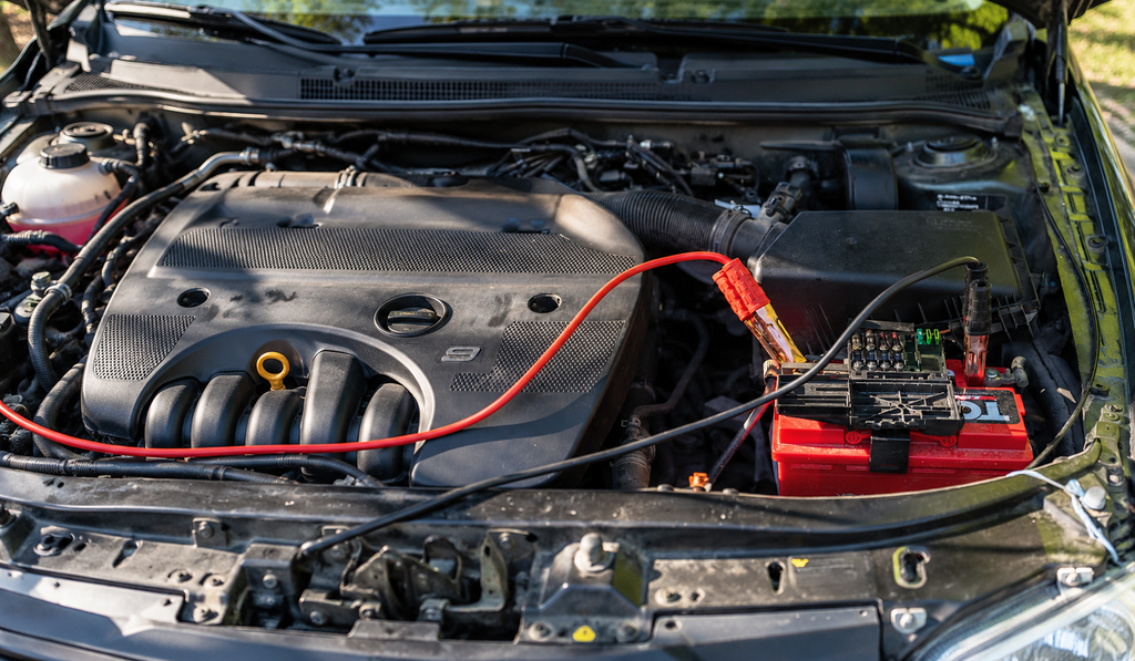 A car battery with heavy power cables connected in an engine bay