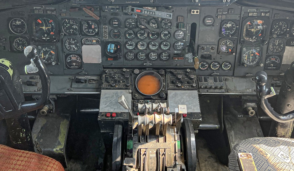A close view of instrument dials and controls inside an older aircraft cockpit.